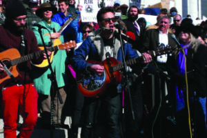 Tom Bennett (center) performing before a crowd of 5,000 at the Clean Air, No Excuses Rally at the Capitol in January.