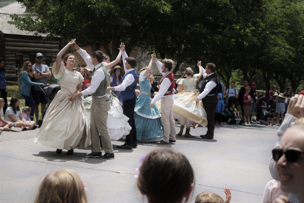 Dancers dressed in traditional pioneer outfits dancing for a crowd. Photo courtesy of This is the Place State Park.